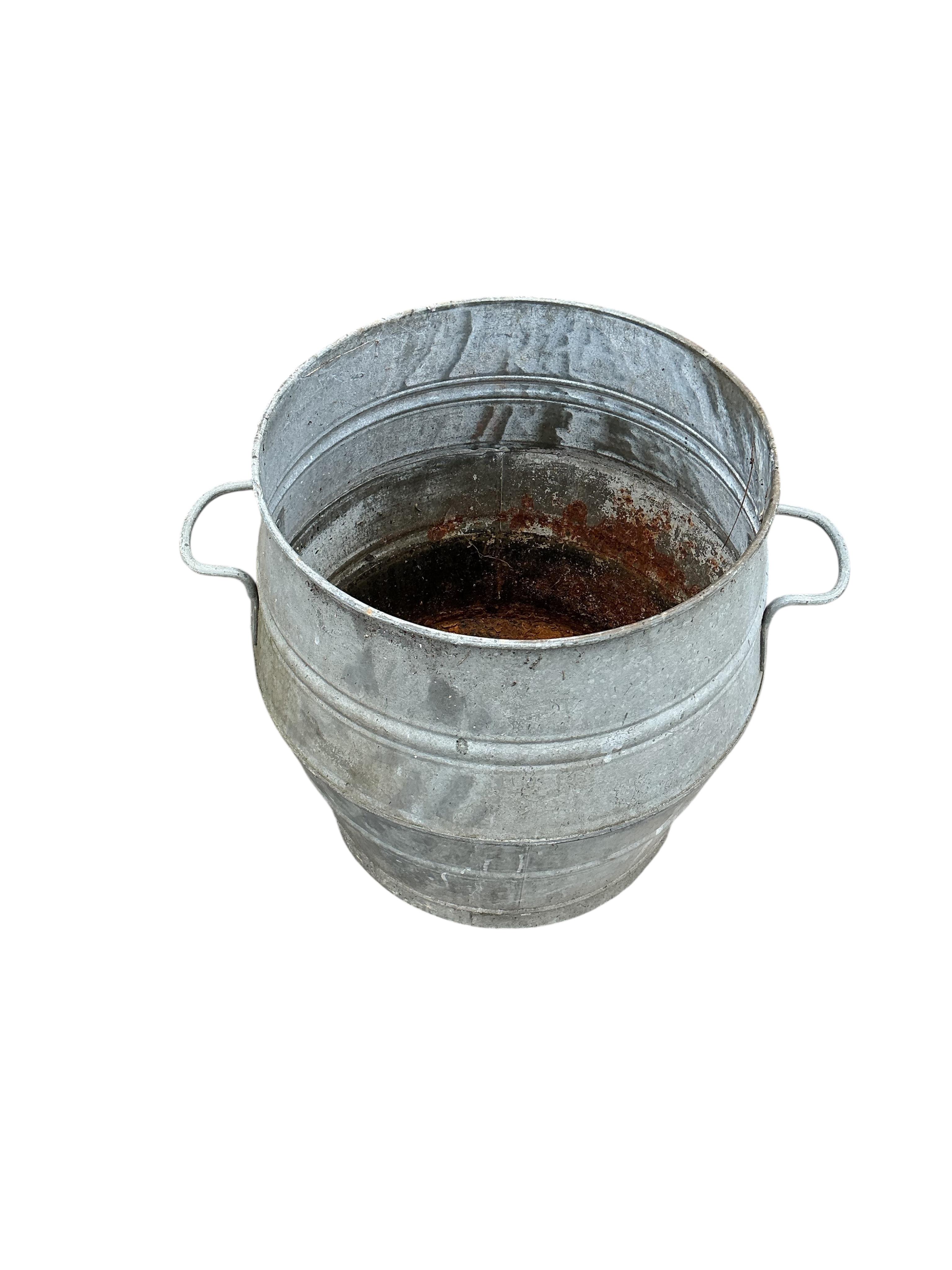 A near pair of circular galvanised metal barrels, diameter 46cm, height 52cm
